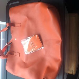 Orange handbag with luggage tag.